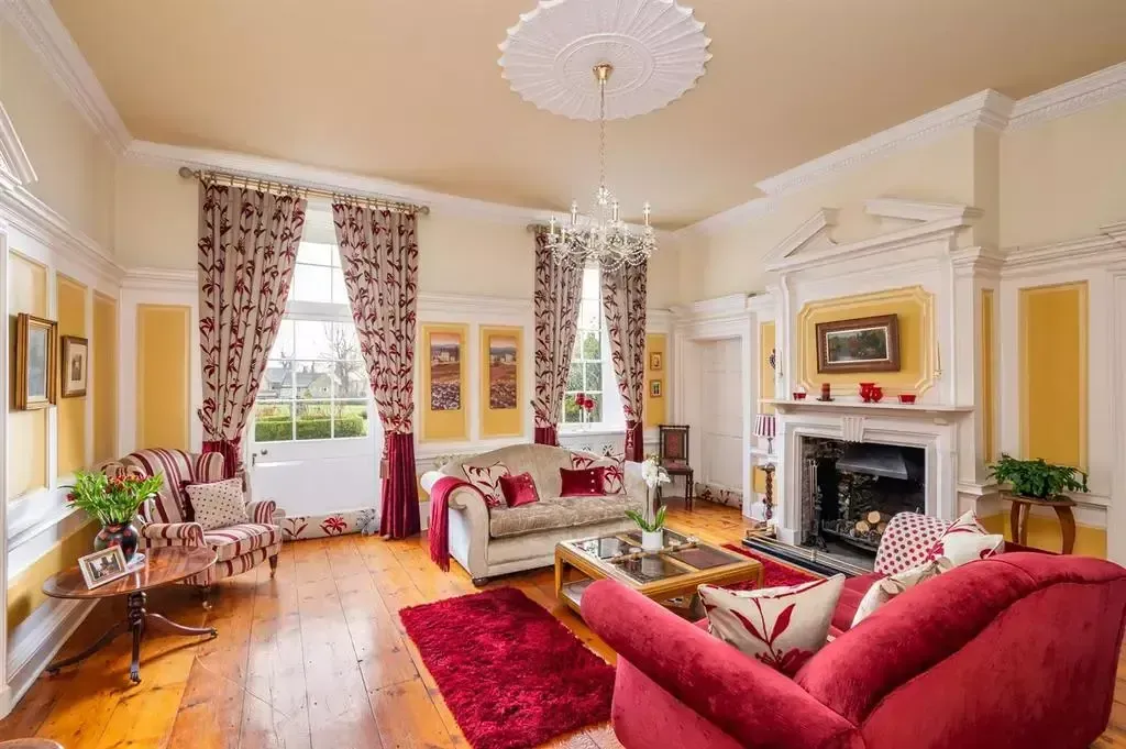 Flawlessly finished period drawing room – warm cream and yellow finishes highlighting ornate fireplace and mouldings.