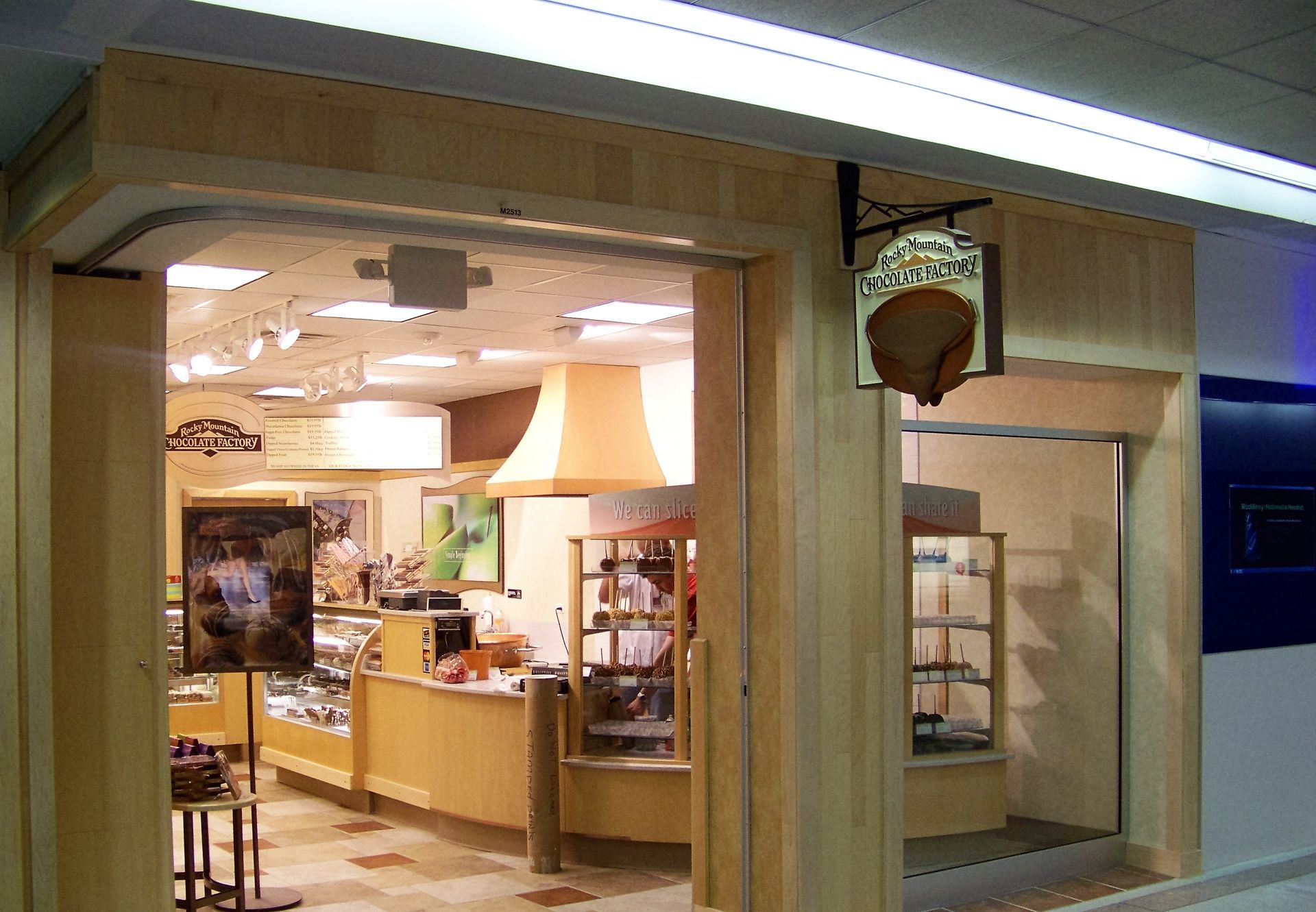 Storefront of a cozy bakery or café with warm lights and display cases visible inside