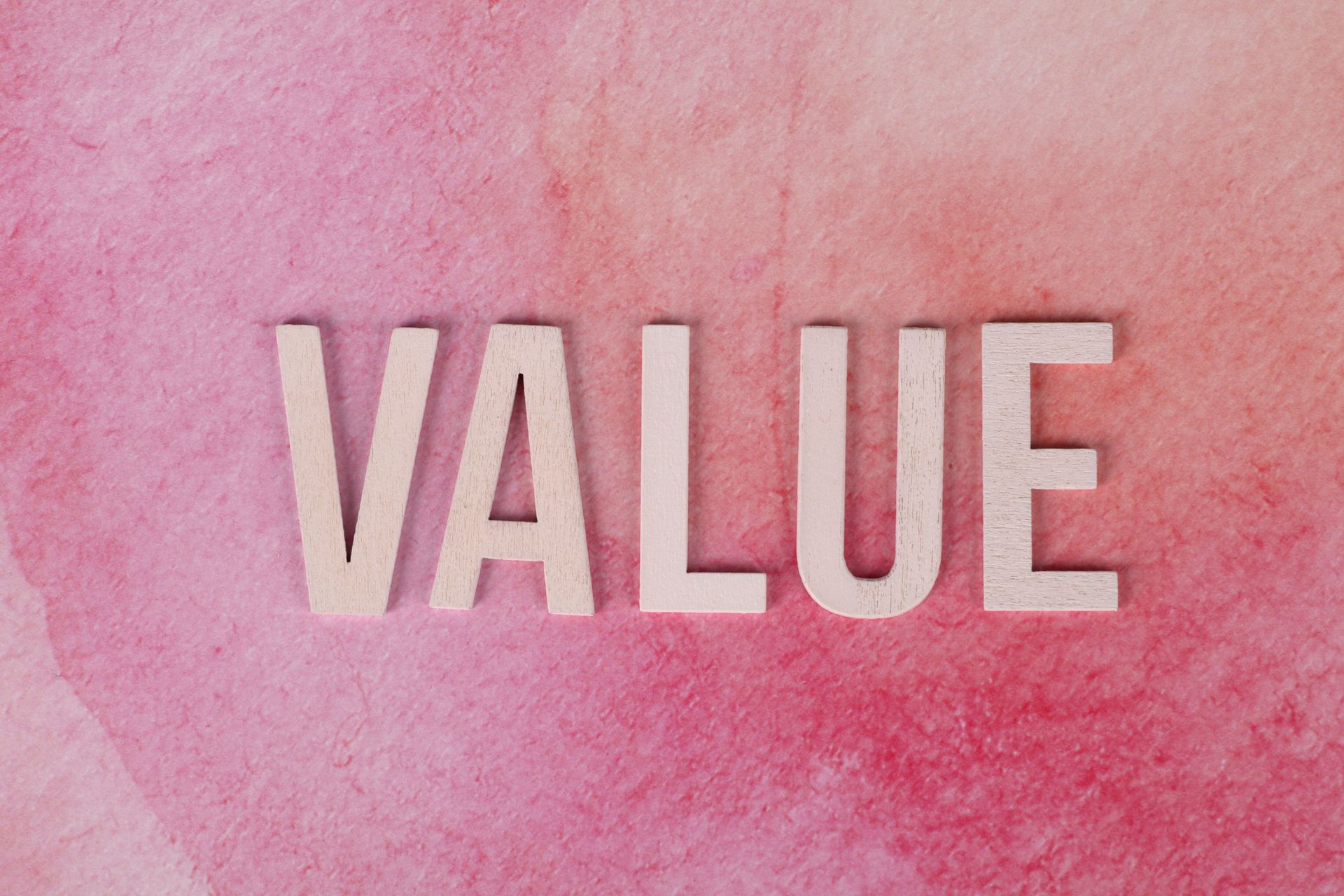 White “VALUE” text on a pink watercolor background.