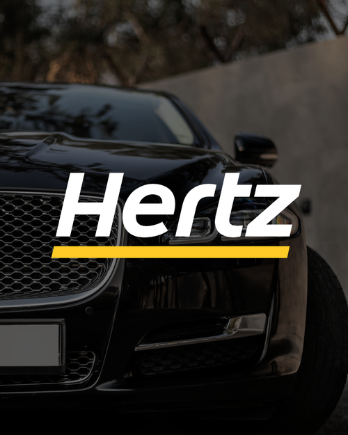 Logotipo de Hertz sobre la parrilla delantera de un coche de lujo negro.