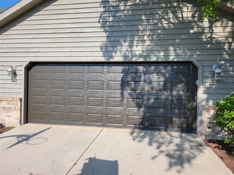 A white garage with a blue roof has a potted plant in front of it A white garage with a blue roof has a potted plant in front of it