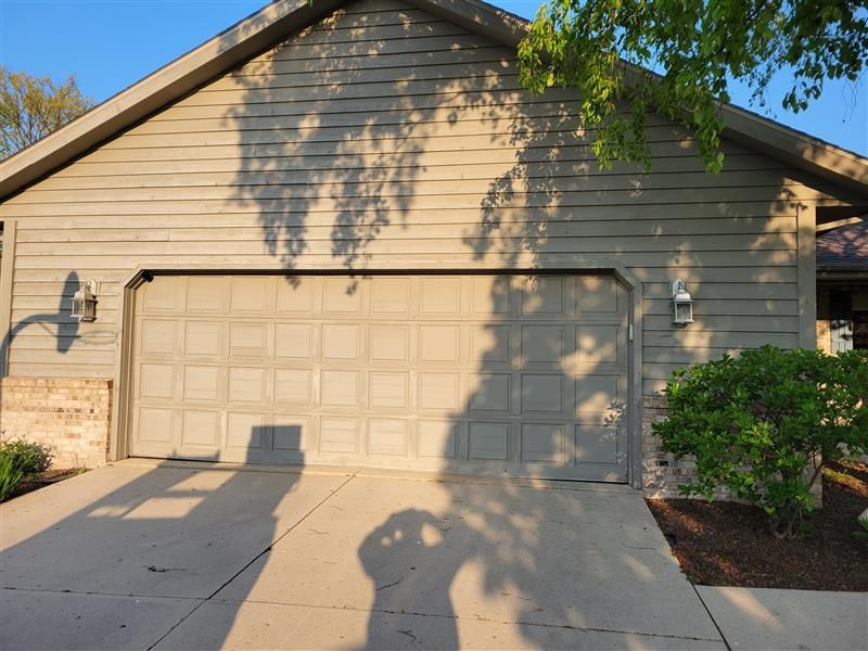 A house with a blue garage door and a brown roof. A house with a blue garage door and a brown roof.