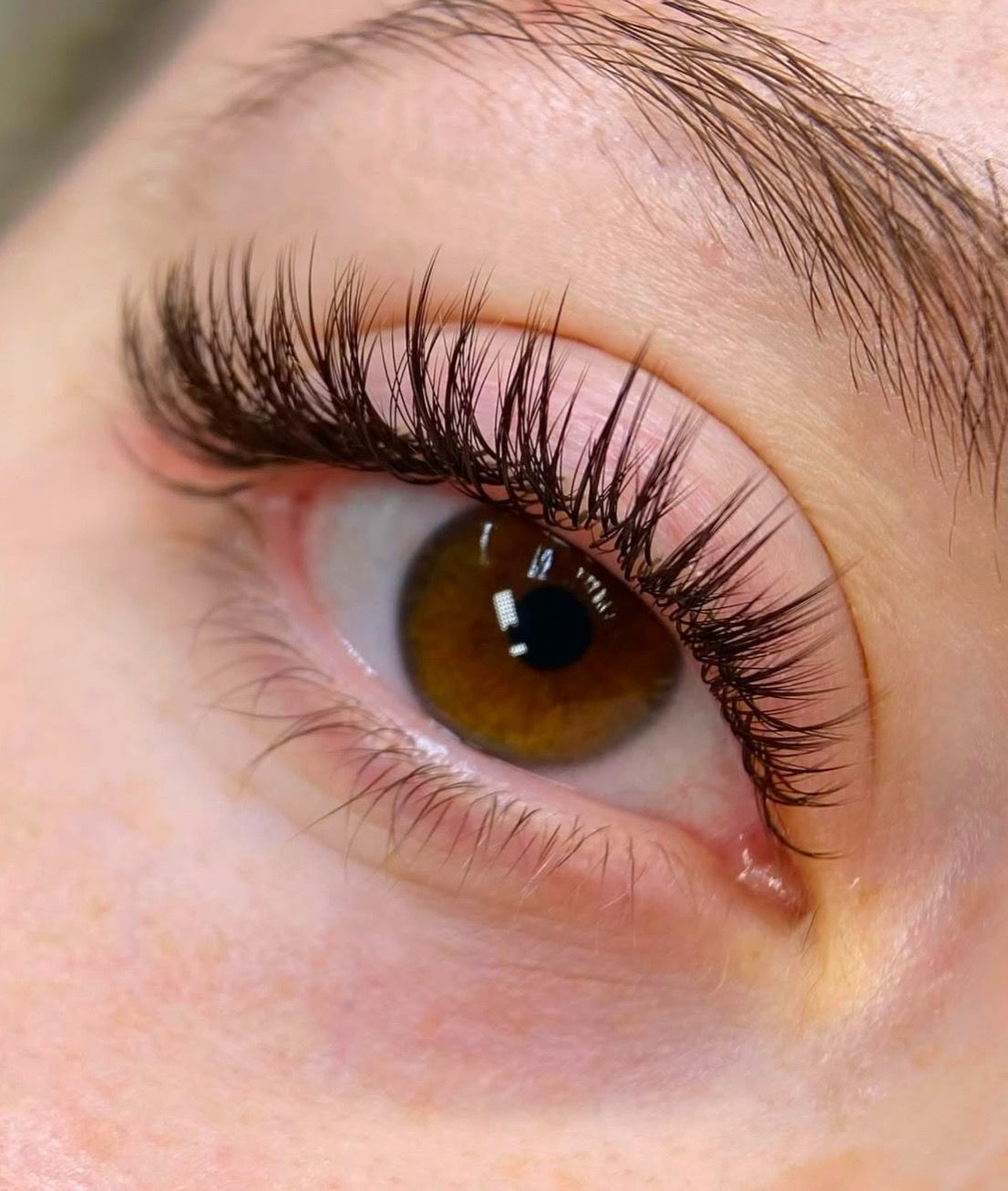 A close up of a woman 's eye with long eyelashes.