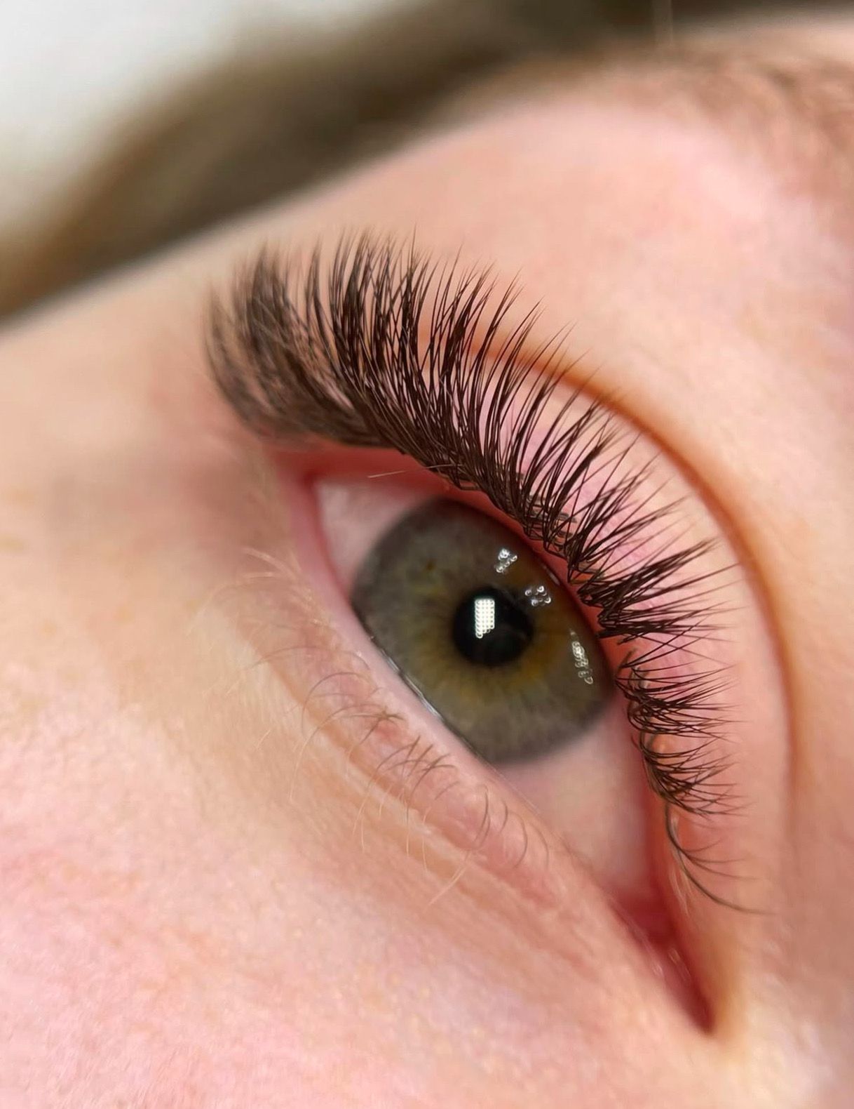 A close up of a woman 's eye with long eyelashes.