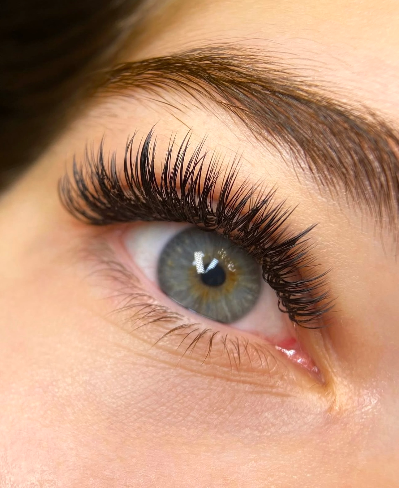 A close up of a woman 's eye with long eyelashes.