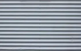 A close up of a gray corrugated metal wall.