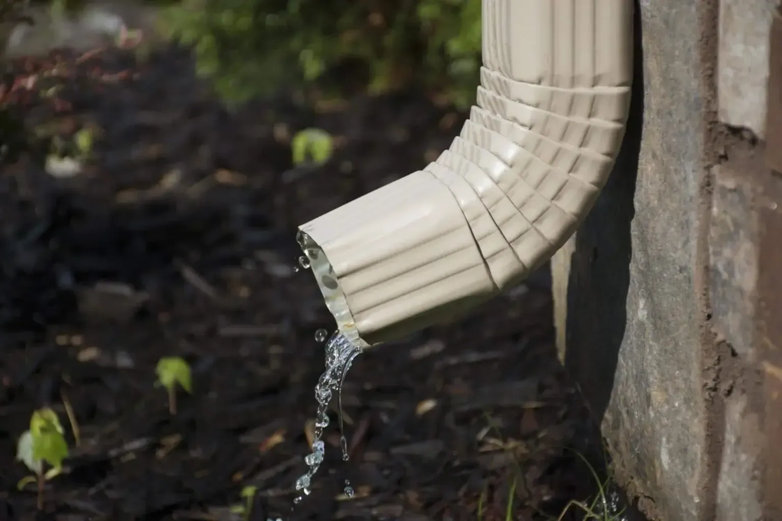 A close up of a drainpipe with water coming out of it