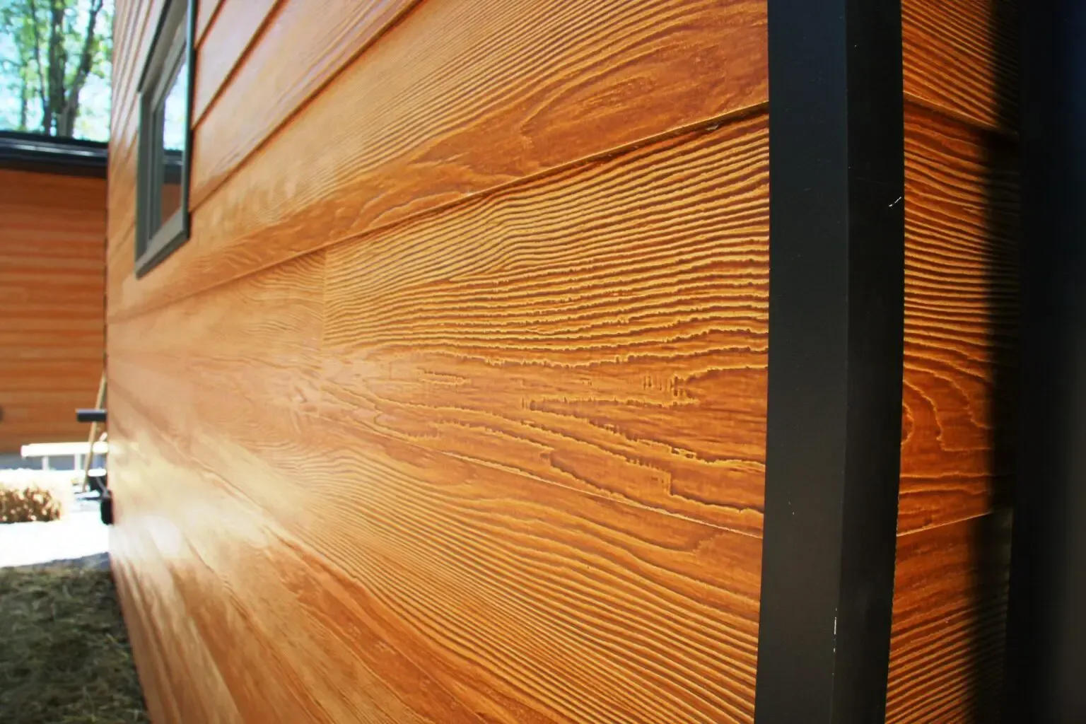 A close up of a wooden house with a black trim