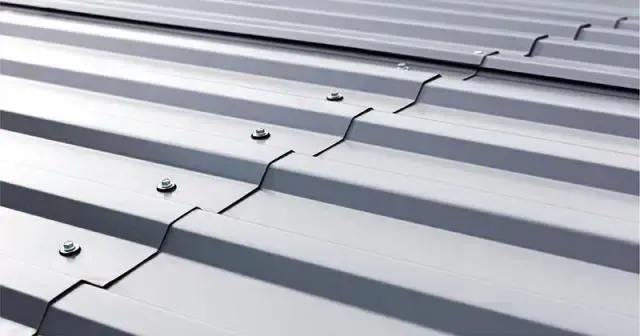 A close up of a metal roof with screws on it.