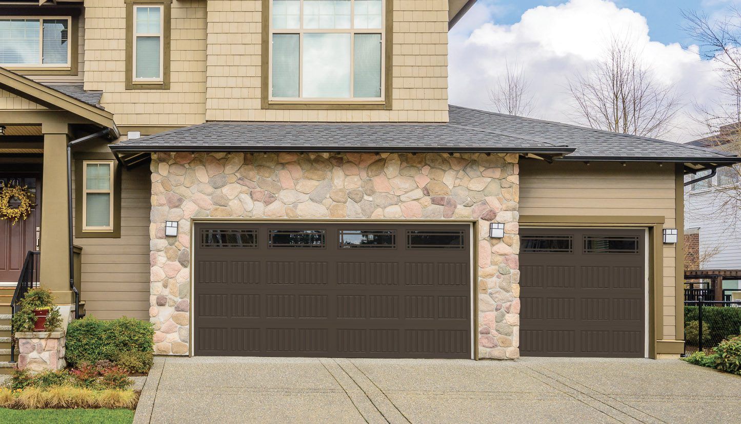 A house with two garage doors and a driveway in front of it.
