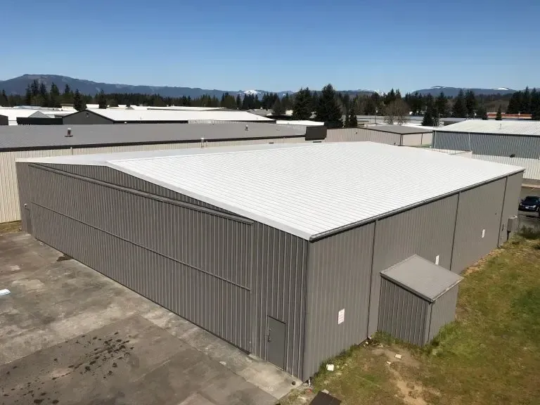 An aerial view of a large building with a white roof