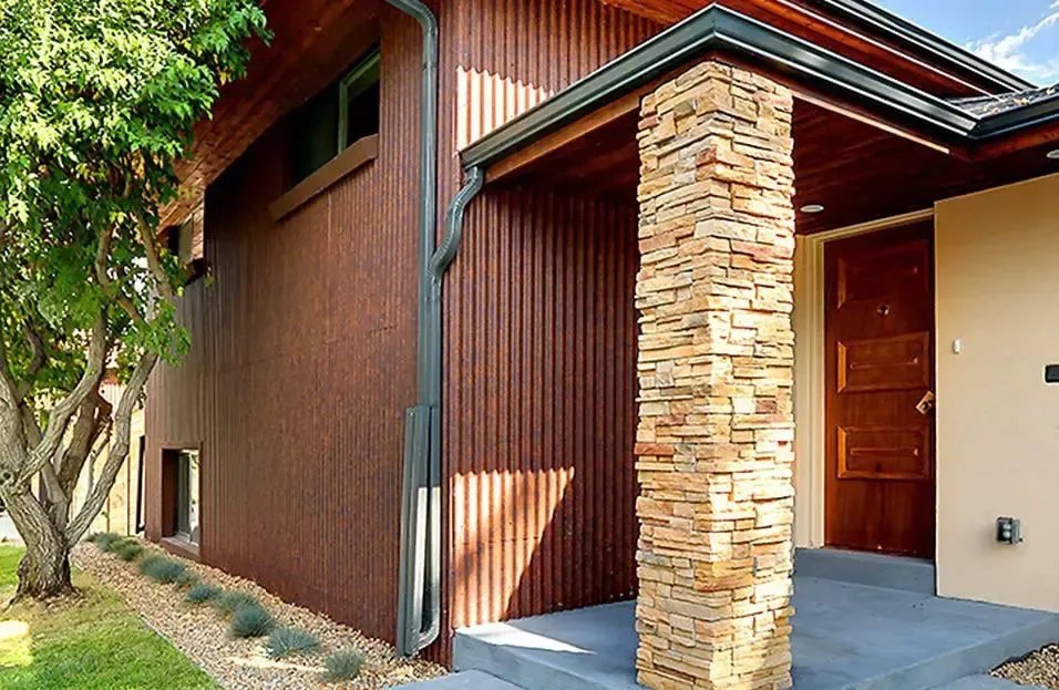 A house with a stone pillar in front of it