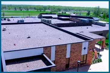 An aerial view of a large brick building with a flat roof