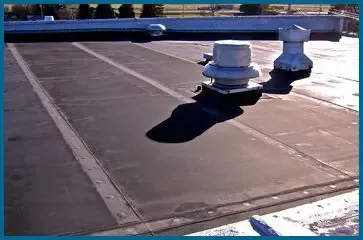 A black object is hanging from a pole in a parking lot.