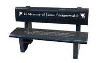 A black granite memorial bench engraved with
