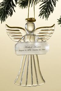 A glass angel ornament hanging from a pine branch, inscribed with “Herbert Hoover” and his birth and death dates.