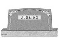 A gray granite tombstone with an arched top, decorative floral carvings, and the name