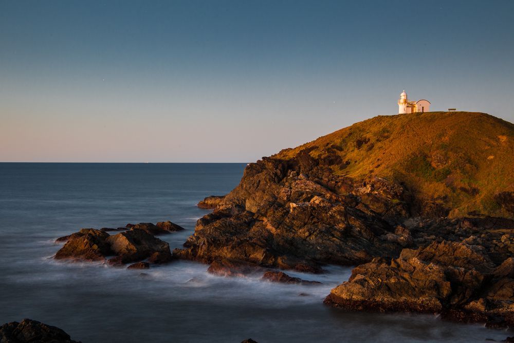 A Lighthouse On Top Of A Rocky Hill Overlooking The Ocean — Millers Masonry In Port Macquarie, NSW