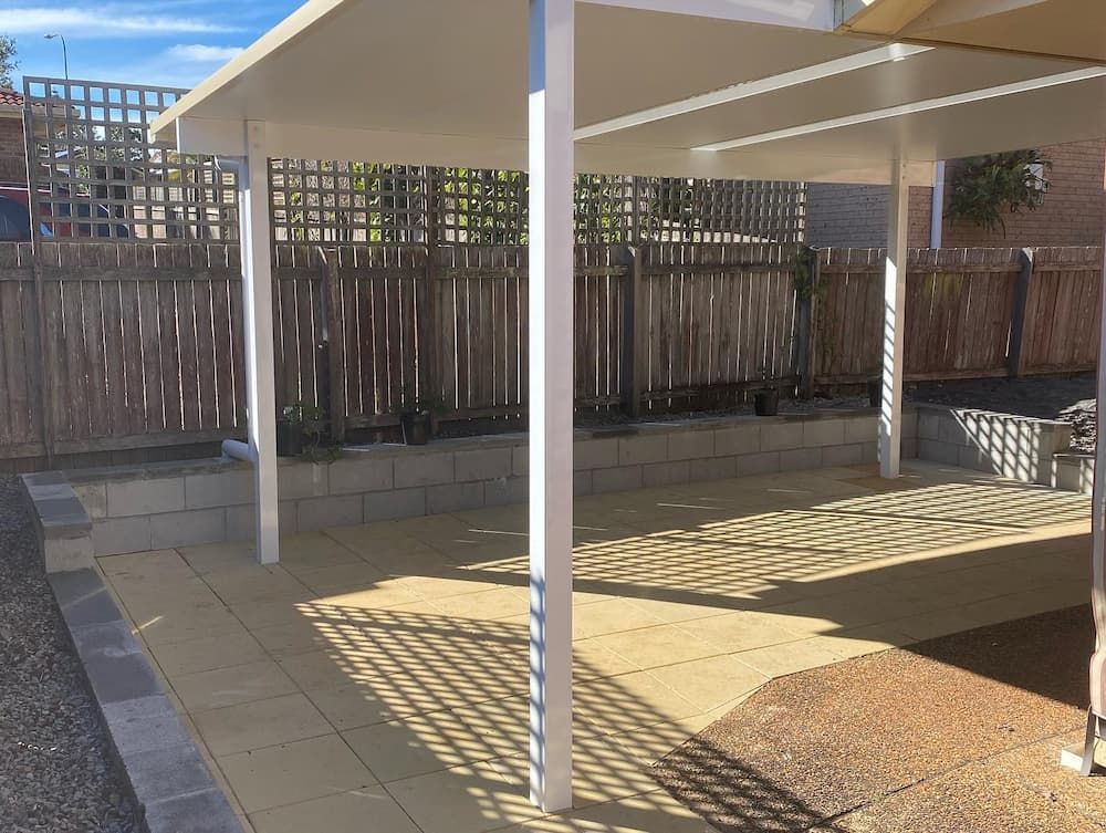 Patio with White Columns, Tan Roof, and Wood Fence — Millers Masonry In Port Macquarie, NSW