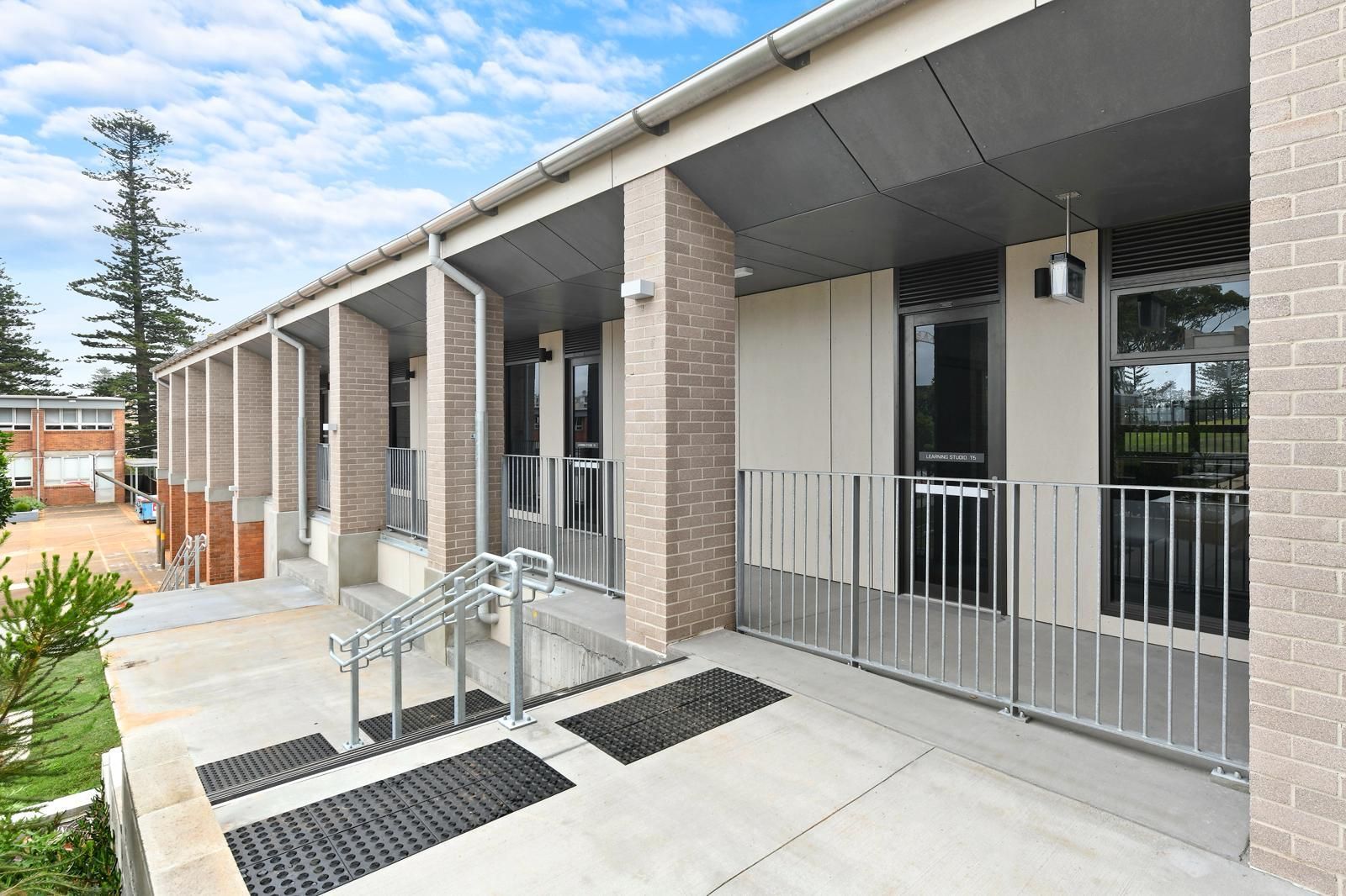 Covered building entrance with ramp, steps, railings, and brick columns — Millers Masonry In Port Macquarie, NSW