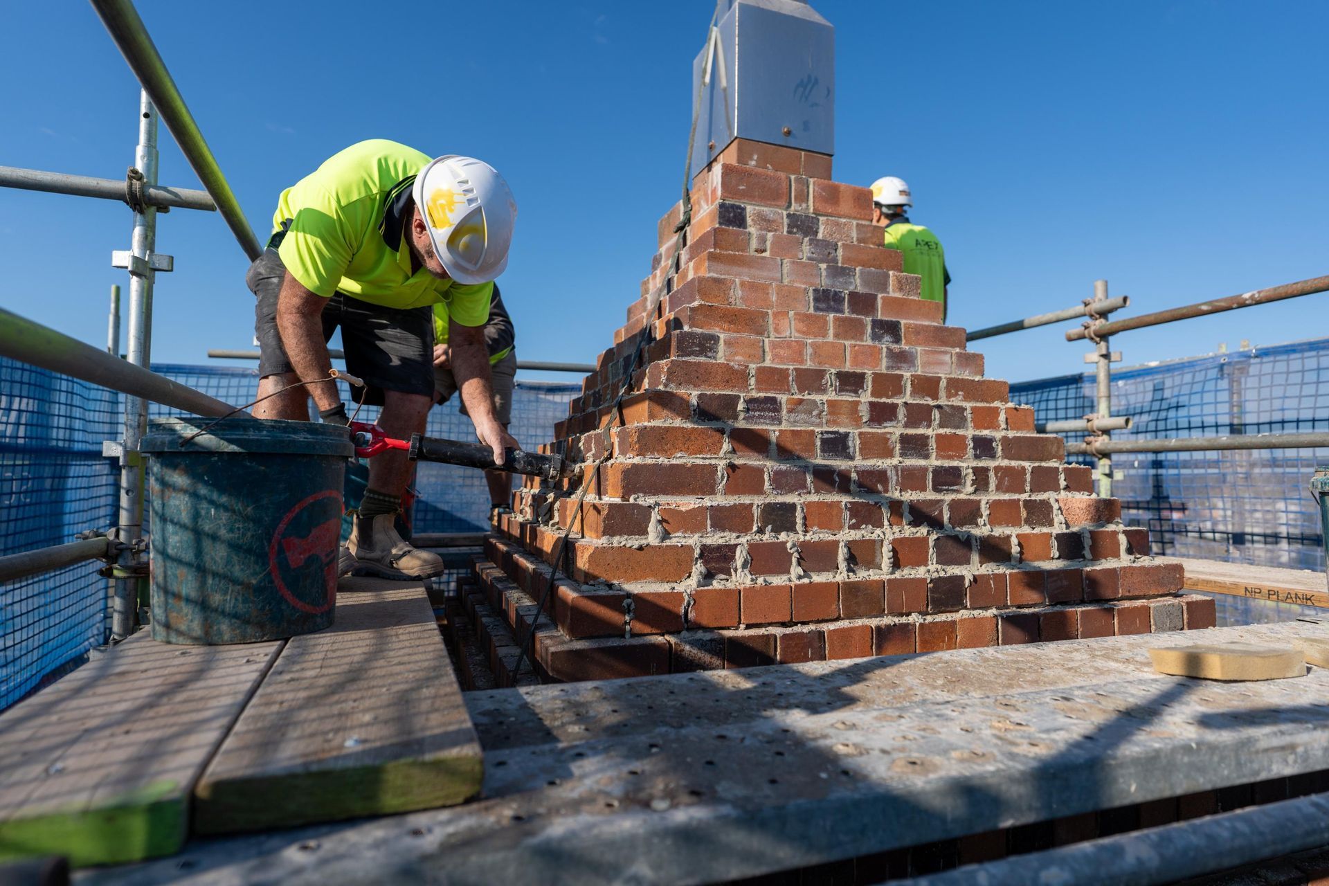 A Bricklayer on Scaffolding Builds a Chimney — Millers Masonry In Port Macquarie, NSW