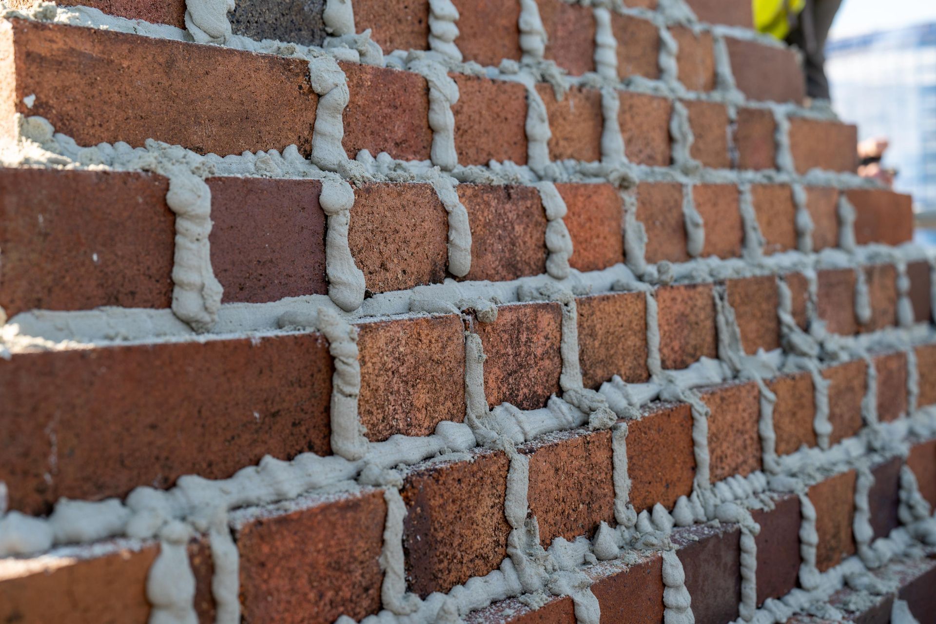 Bricks Being Laid in A Wall with Grey Mortar — Millers Masonry In Port Macquarie, NSW