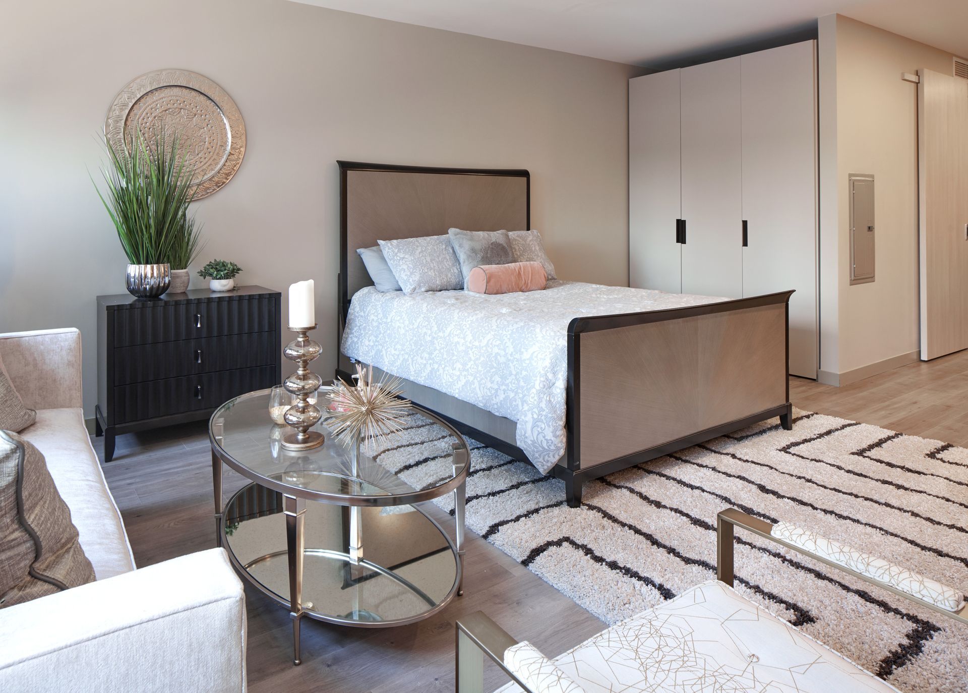 A bedroom with a bed , couch , coffee table and rug