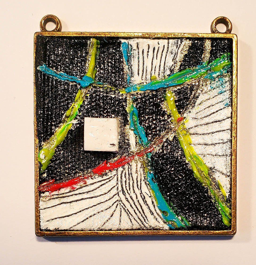 A square pendant with a colorful design on it