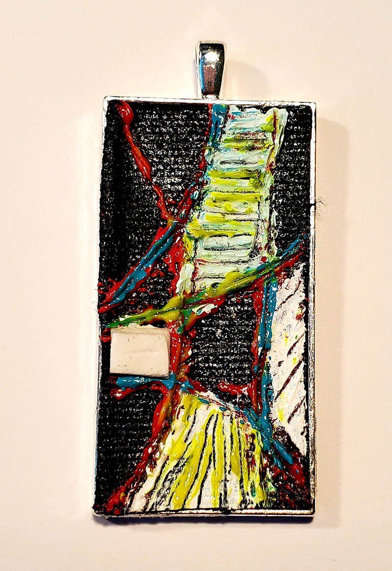 A colorful pendant is hanging on a white wall.