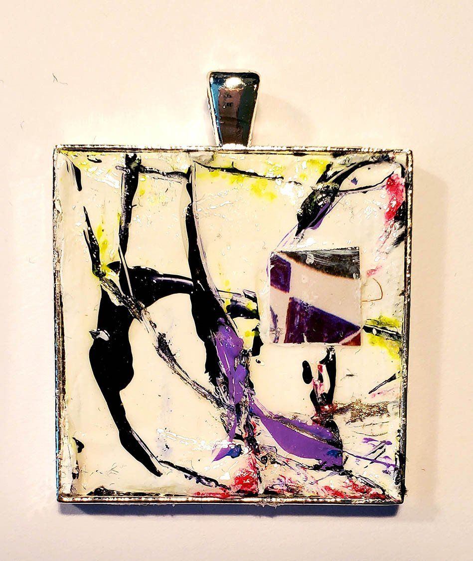 A square pendant with a colorful design on it