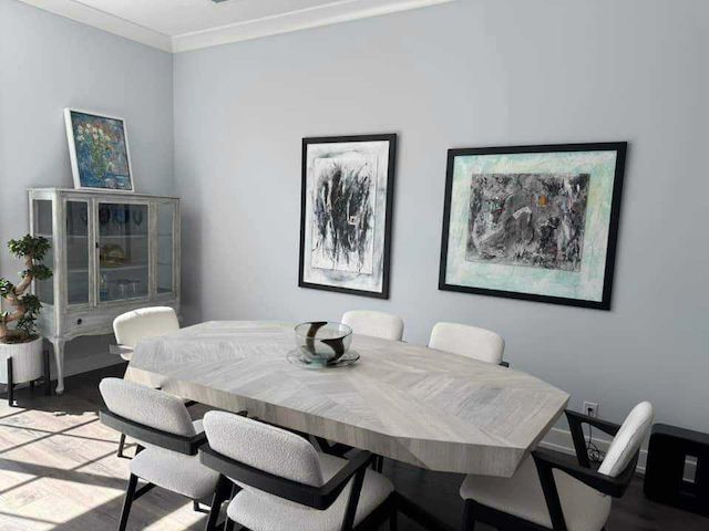 A dining room with a table and chairs and paintings on the wall.