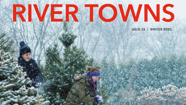 The cover of river towns magazine shows two people cutting christmas trees