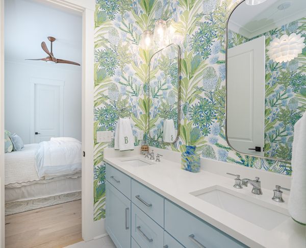 A Bathroom With Blue Cabinets, A Sink, A Mirror And A Ceiling Fan - Countertop Specialists in Savannah, GA