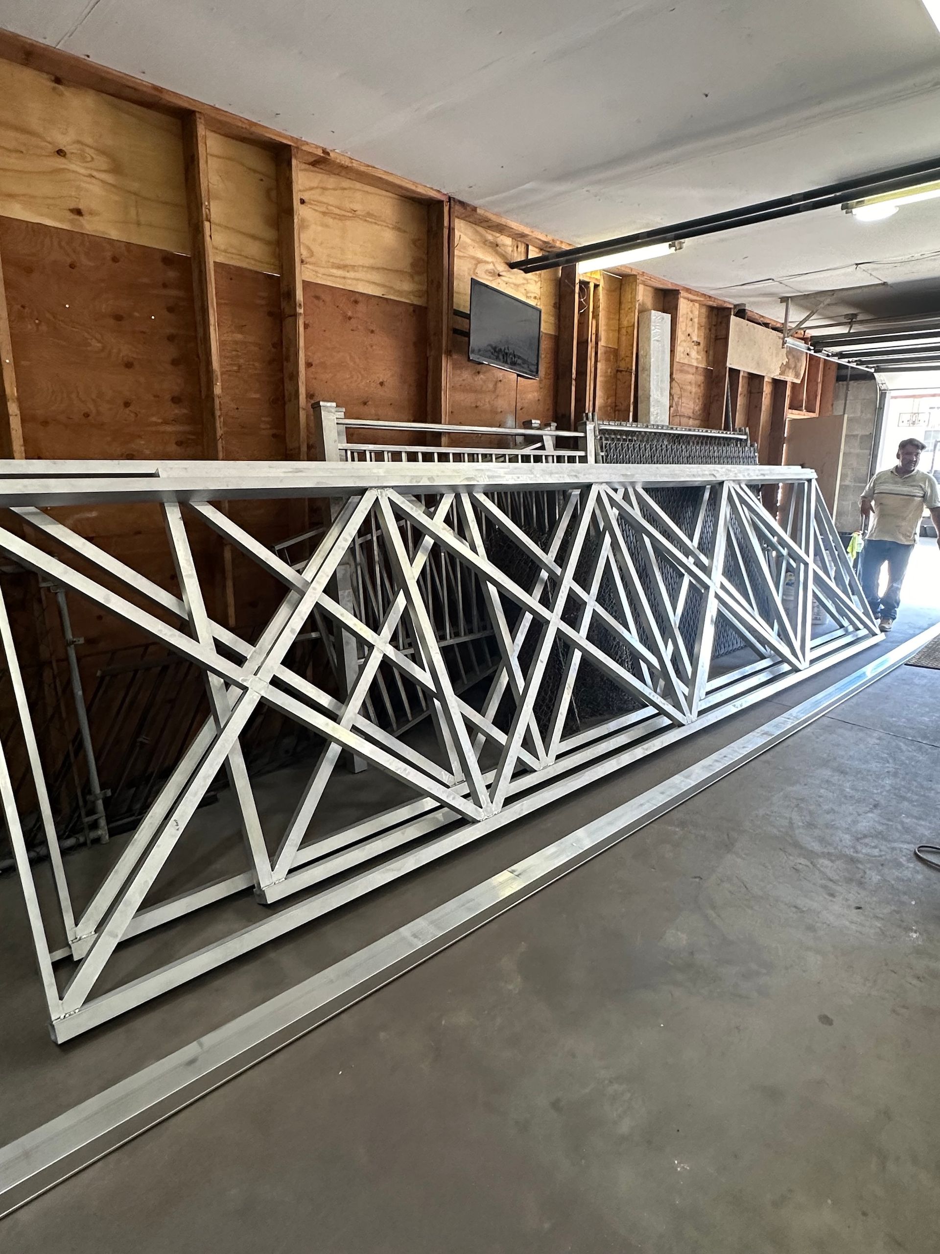 White metal truss structures inside a garage, next to a person.