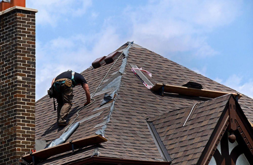 A man is working on the roof of a house.