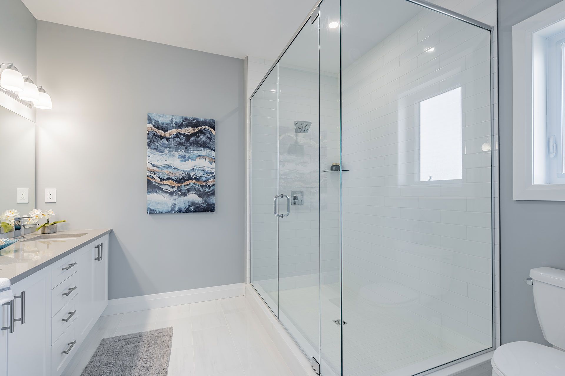 A bathroom with a walk in shower and a toilet  in Fidelity Homes Signature build in Cramahe Township
