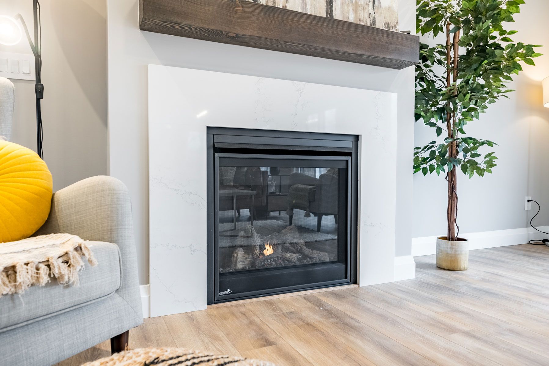 A living room with a fireplace and a plant of a Fidelity Homes Signature Build custom home in Colborne Ontario