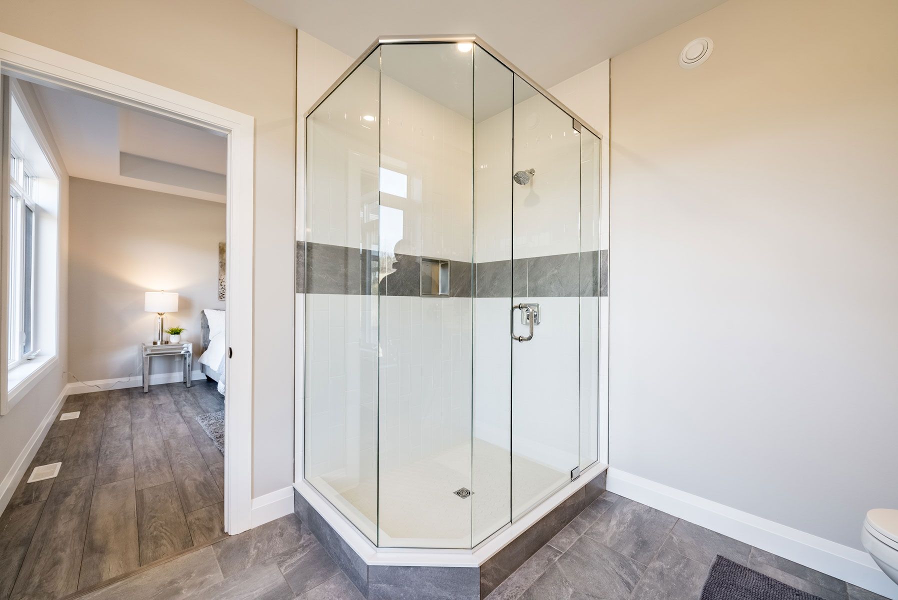 A bathroom with a walk in shower and a toilet  in Fidelity Homes Signature build in Cramahe Township