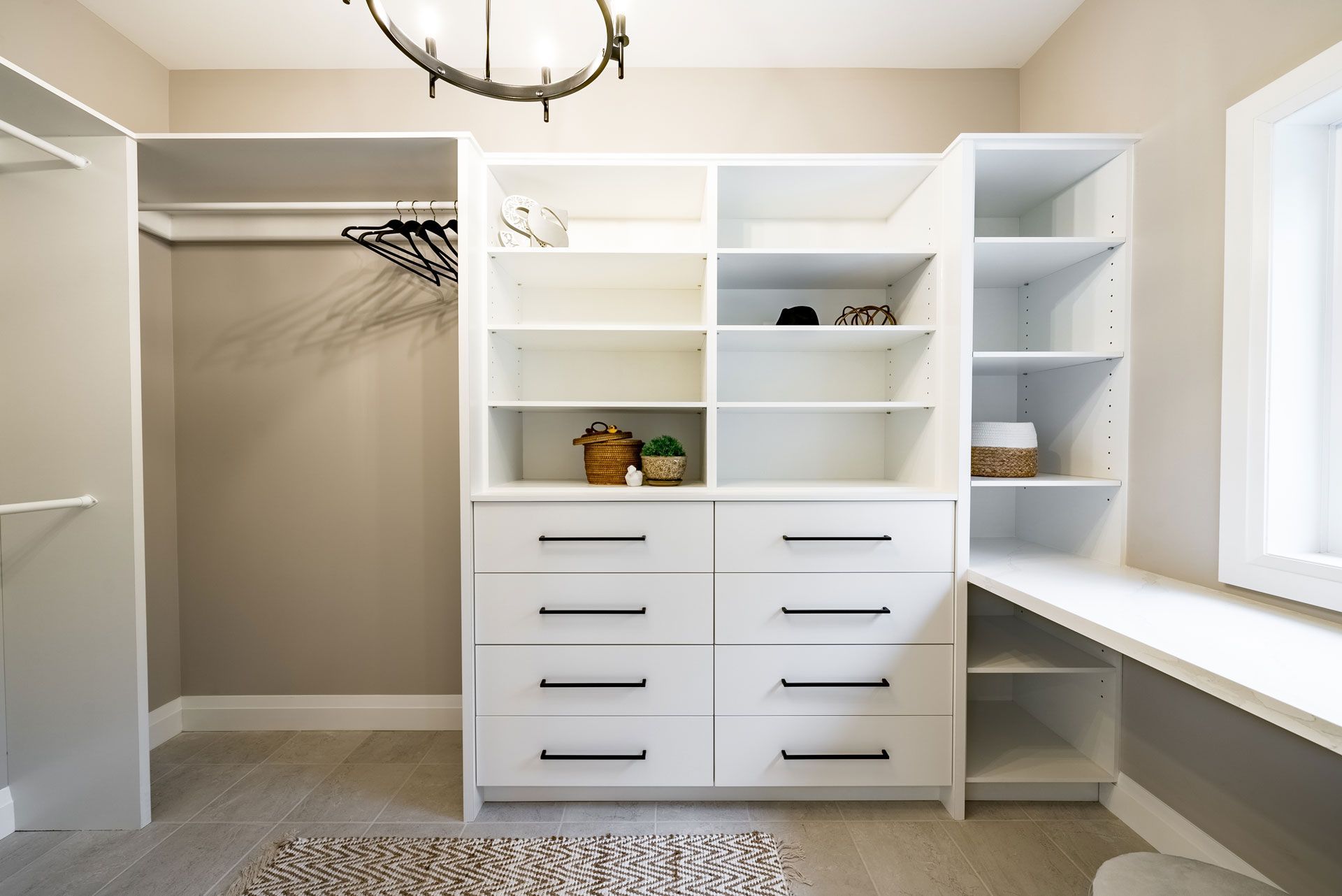 A walk in closet with lots of shelves and drawers and a desk 