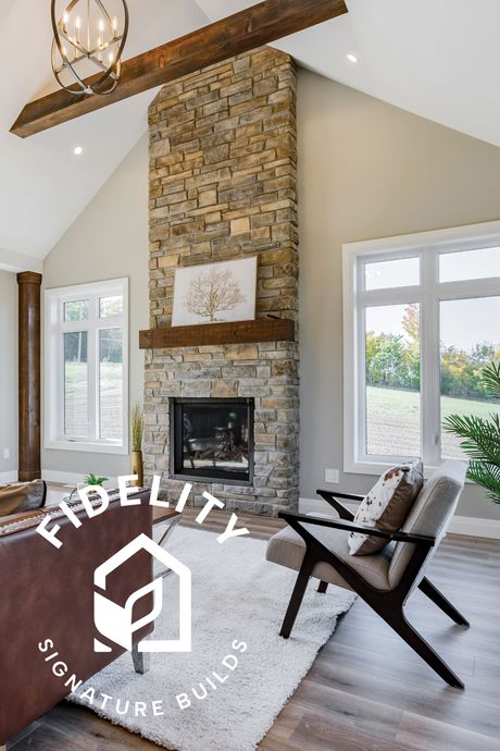 A living room with a fireplace and a Fidelity Homes Signature builds logo