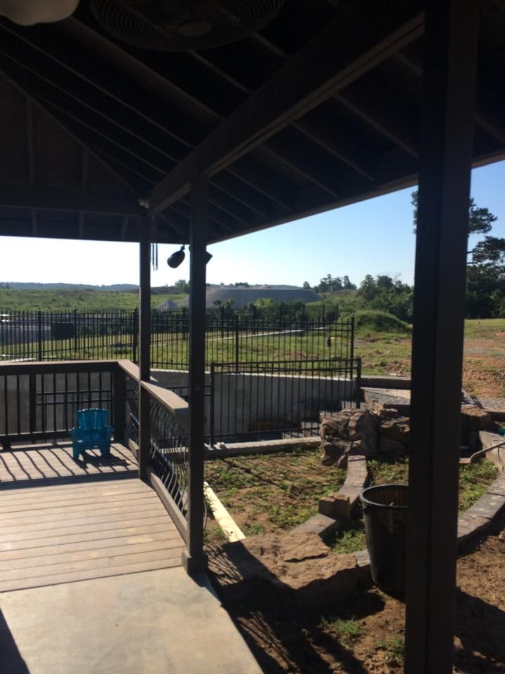 A porch with a view of a field and a fence