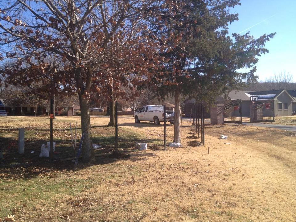A white van is parked in a yard with trees