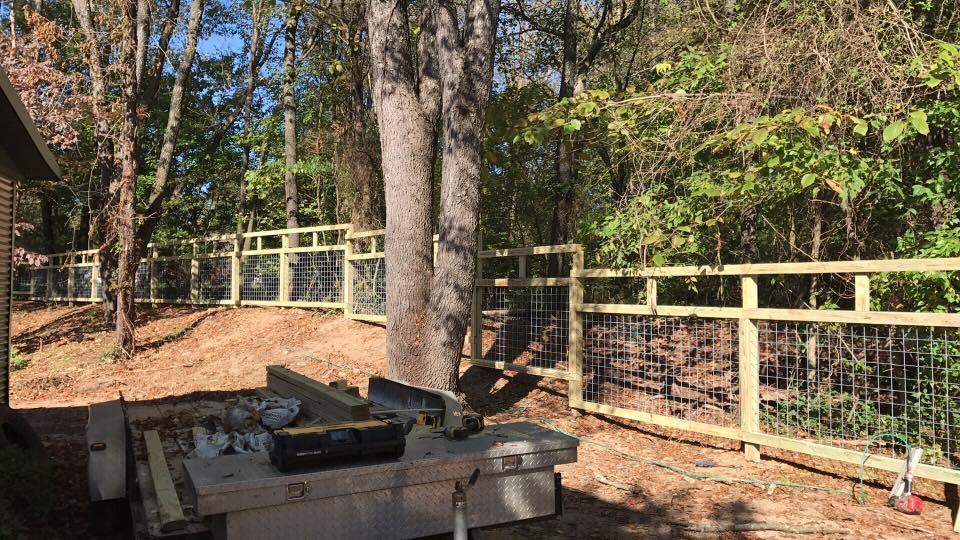 A wooden fence is being built in the middle of a forest.