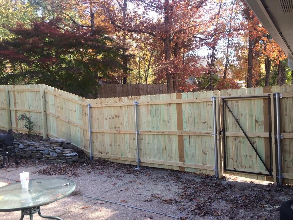 A wooden fence with a gate in the backyard