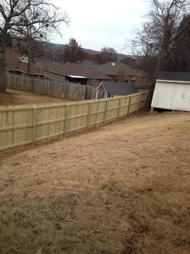 There is a wooden fence in the backyard of a house.