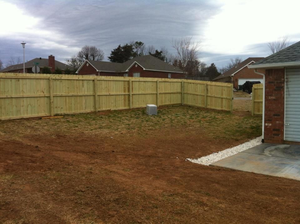 A wooden fence is in the backyard of a house