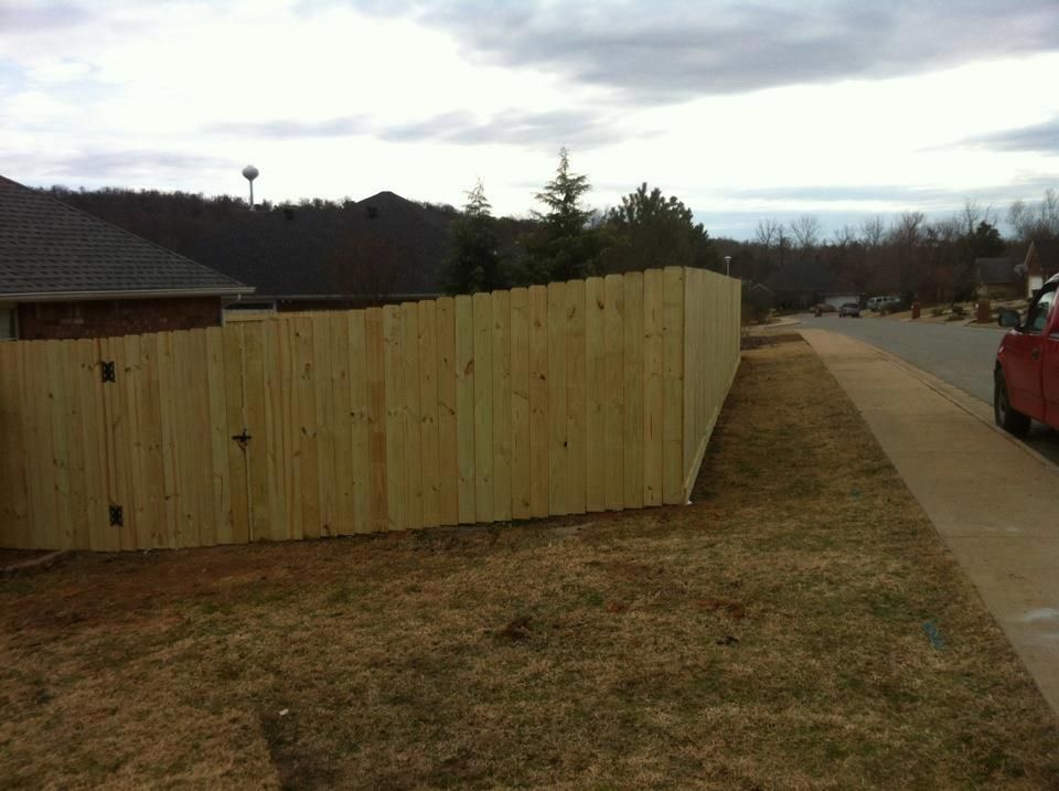A wooden fence with a red truck parked in front of it