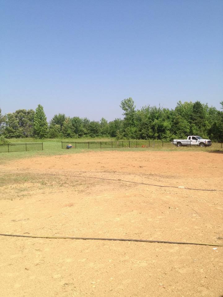 A truck is parked in the middle of a dirt field.