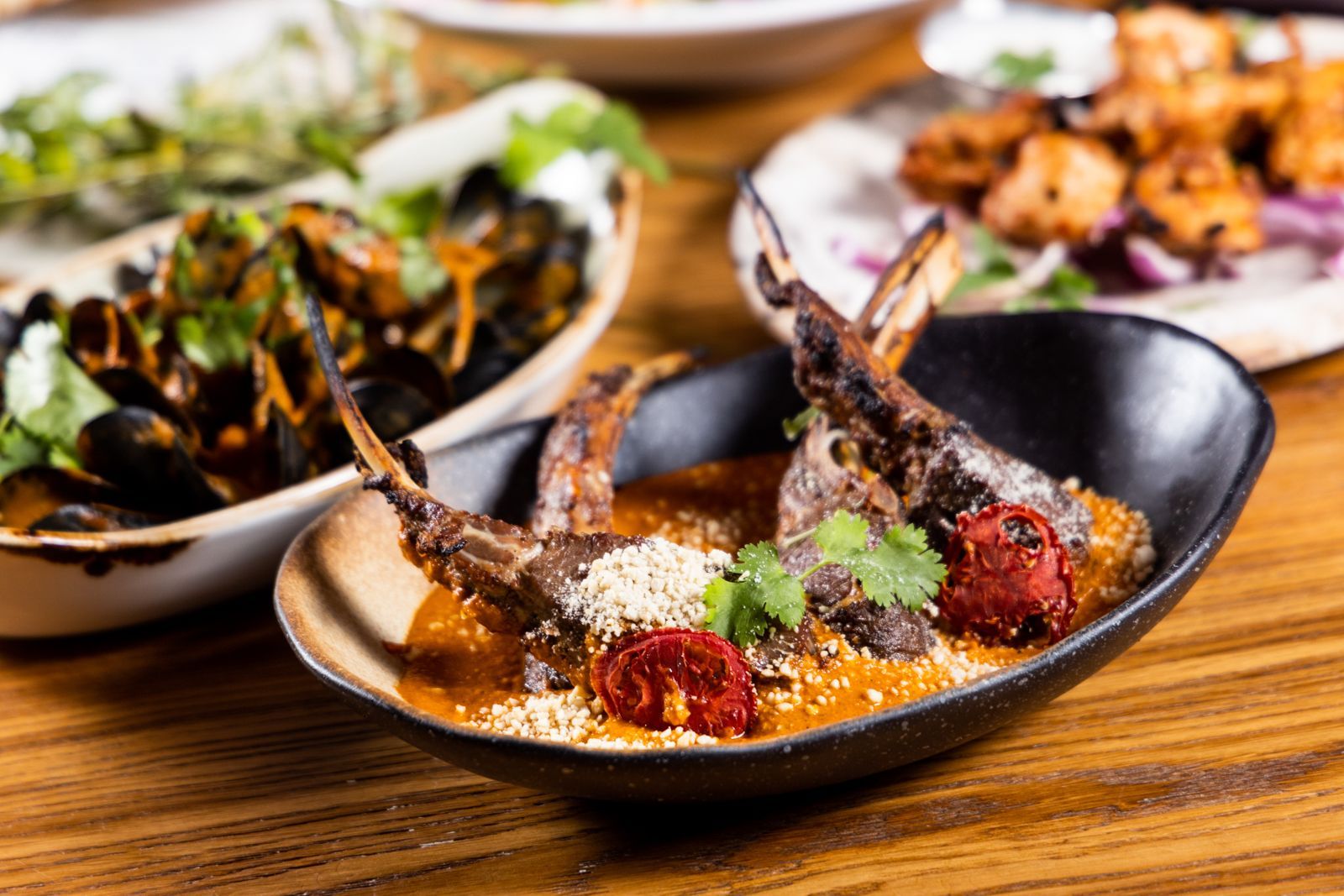 Signature dish of Kama with 4 charcoal grilled lamb chops, cashews, creamed tomatoes