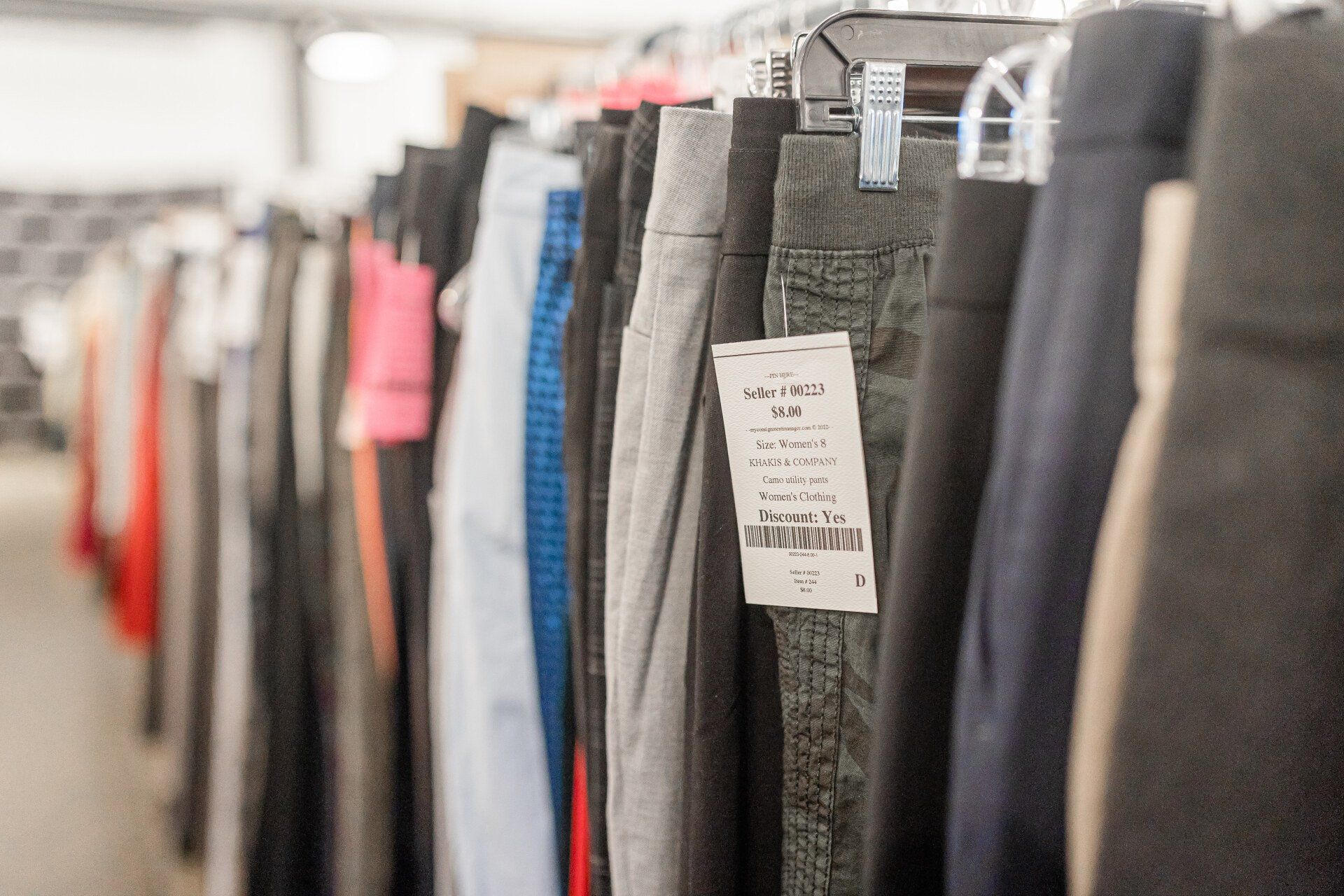 A row of pants hanging on a rack in a store